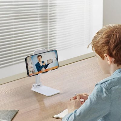 support telephone garçon visionne son téléphone Blanco